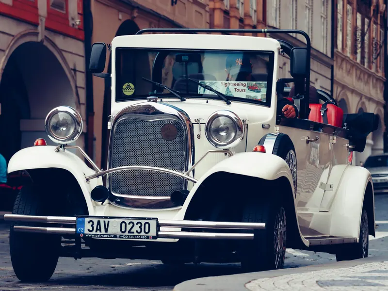 White vintage cabriolet replica parked on a Prague cobbled lane